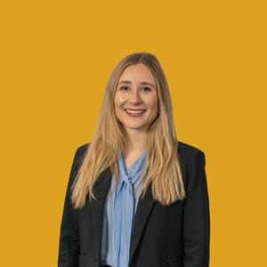 Lächelnde Frau vor gelbem Hintergrund.