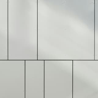 Nahaufnahme einer weissen Wand mit rechteckigen Paneelen.