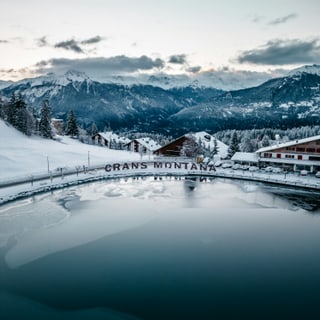 Schneebedeckte Berge und See in Crans-Montana im Winter.
