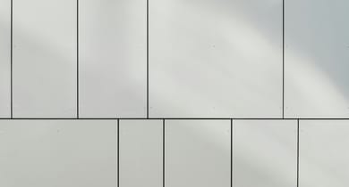 Nahaufnahme einer weissen Wand mit rechteckigen Paneelen.