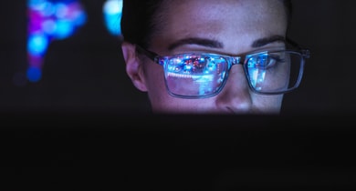 Frau mit Brille vor dem Computer