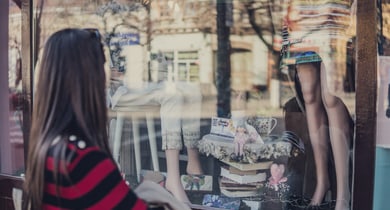 Frau vor Schaufenster Kleiderladen