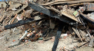 Trümmerhaufen aus verbranntem Holz und Ziegeln.