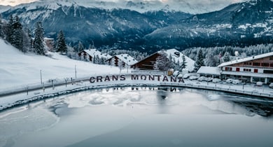 Schneebedeckte Berge und See in Crans-Montana im Winter.