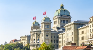 Schweizer Parlamentsgebäude mit Fahnen und Kuppel.