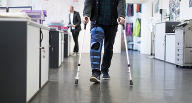 Ein Mann traegt am Arbeitsplatz eine Beinschiene nach einem Skiunfall, aufgenommen am 3. April 2018 in Zuerich. (KEYSTONE/Gaetan Bally)