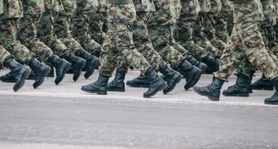 Reihe von Soldaten in Tarnuniformen, die marschieren.