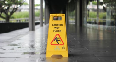 yellow Caution wet floor signage on wet pavement