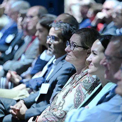 Menschen sitzen aufmerksam bei einer Konferenz im Publikum.