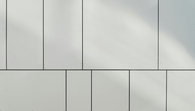 Nahaufnahme einer weissen Wand mit rechteckigen Paneelen.