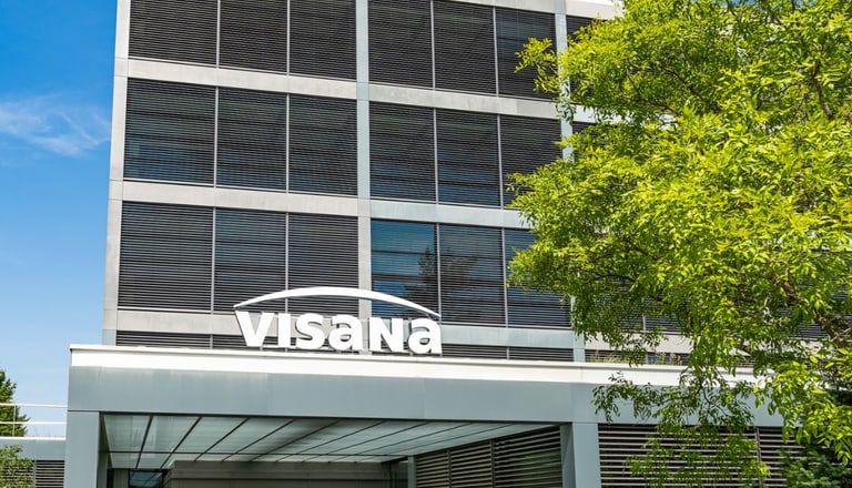 Modernes Bürogebäude mit Visana-Logo bei blauem Himmel.