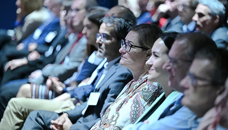 Menschen sitzen aufmerksam bei einer Konferenz im Publikum.