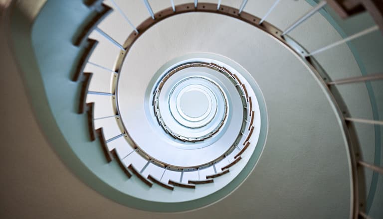 Blick nach oben in ein spiralförmiges Treppenhaus.