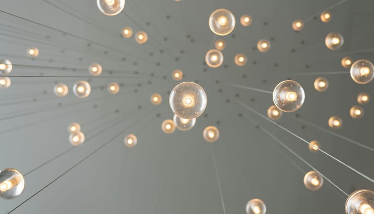 Hängende Glühbirnen an Drähten von unten gesehen.