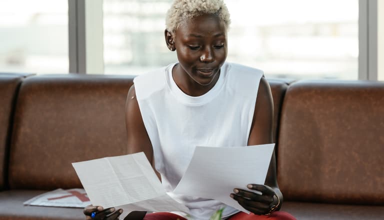 Frau vergleicht leere Zettel (die Lebensversicherungen symbolisieren)