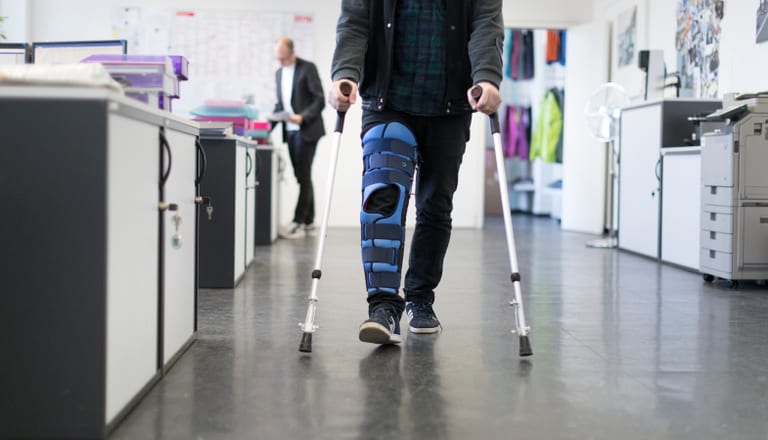 Ein Mann traegt am Arbeitsplatz eine Beinschiene nach einem Skiunfall, aufgenommen am 3. April 2018 in Zuerich. (KEYSTONE/Gaetan Bally)