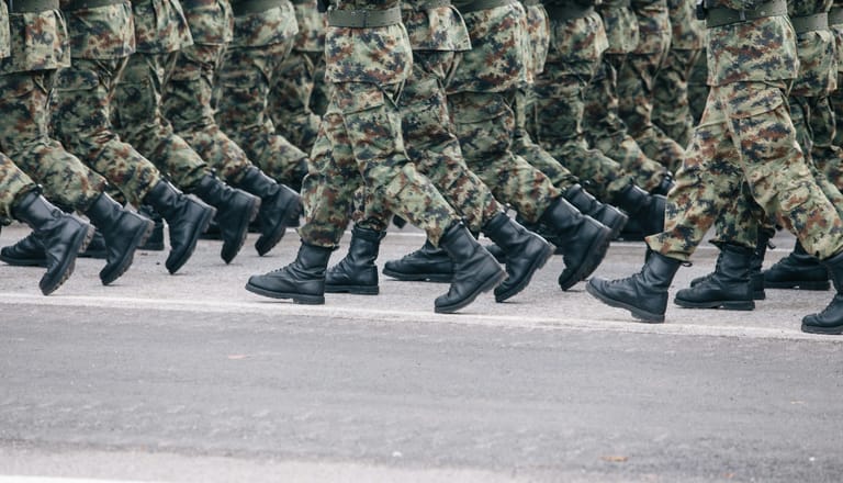 Reihe von Soldaten in Tarnuniformen, die marschieren.