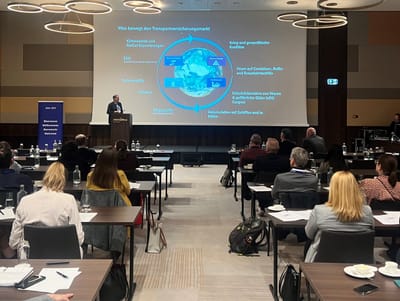 Ein Mann steht auf der Bühne und referiert