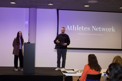Präsentation bei Athletes Network mit Rednern auf der Bühne.
