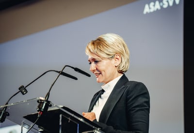 Frau am Rednerpult bei einer Konferenz mit Mikrofonen.