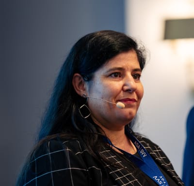 Frau mit Mikrofon spricht auf einer Veranstaltung.