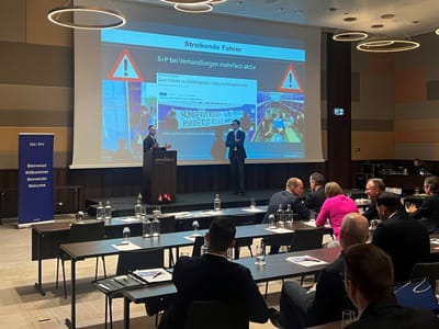 Zwei Personen sitzen auf der Bühne und debatieren