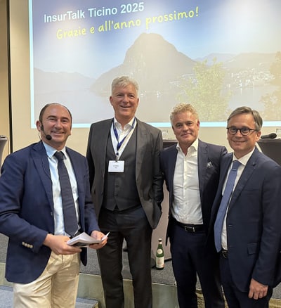 Vier Männer posieren vor einer Präsentationsfolie bei InsurTalk Ticino 2025.