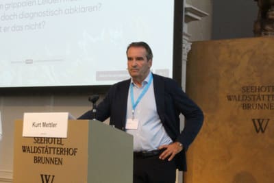 Mann am Podium bei einer Präsentation.
