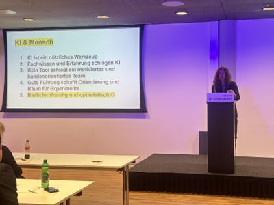 Frau hält Vortrag über KI und Menschen.